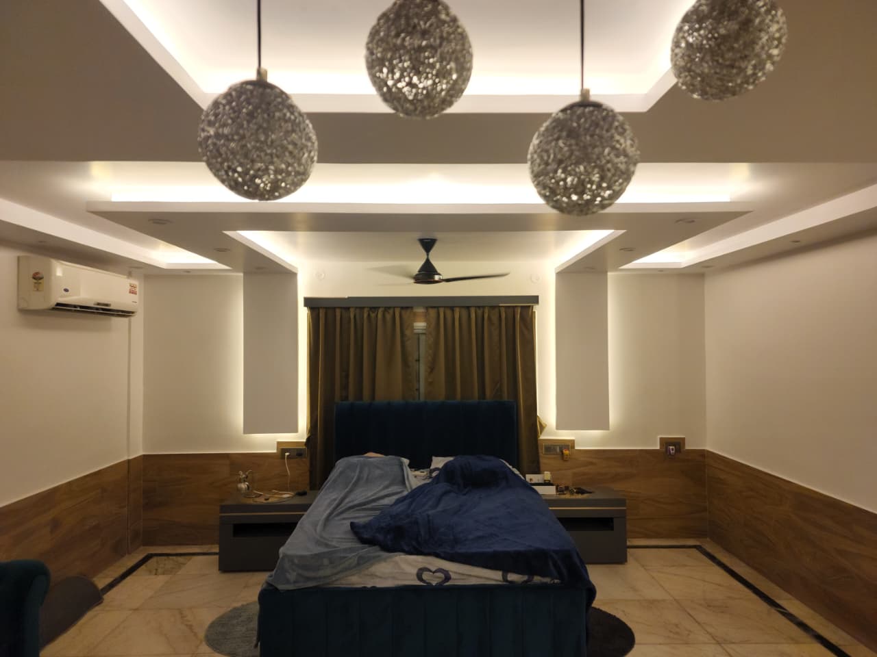 Bedroom interior with layered false ceiling and pendant lighting